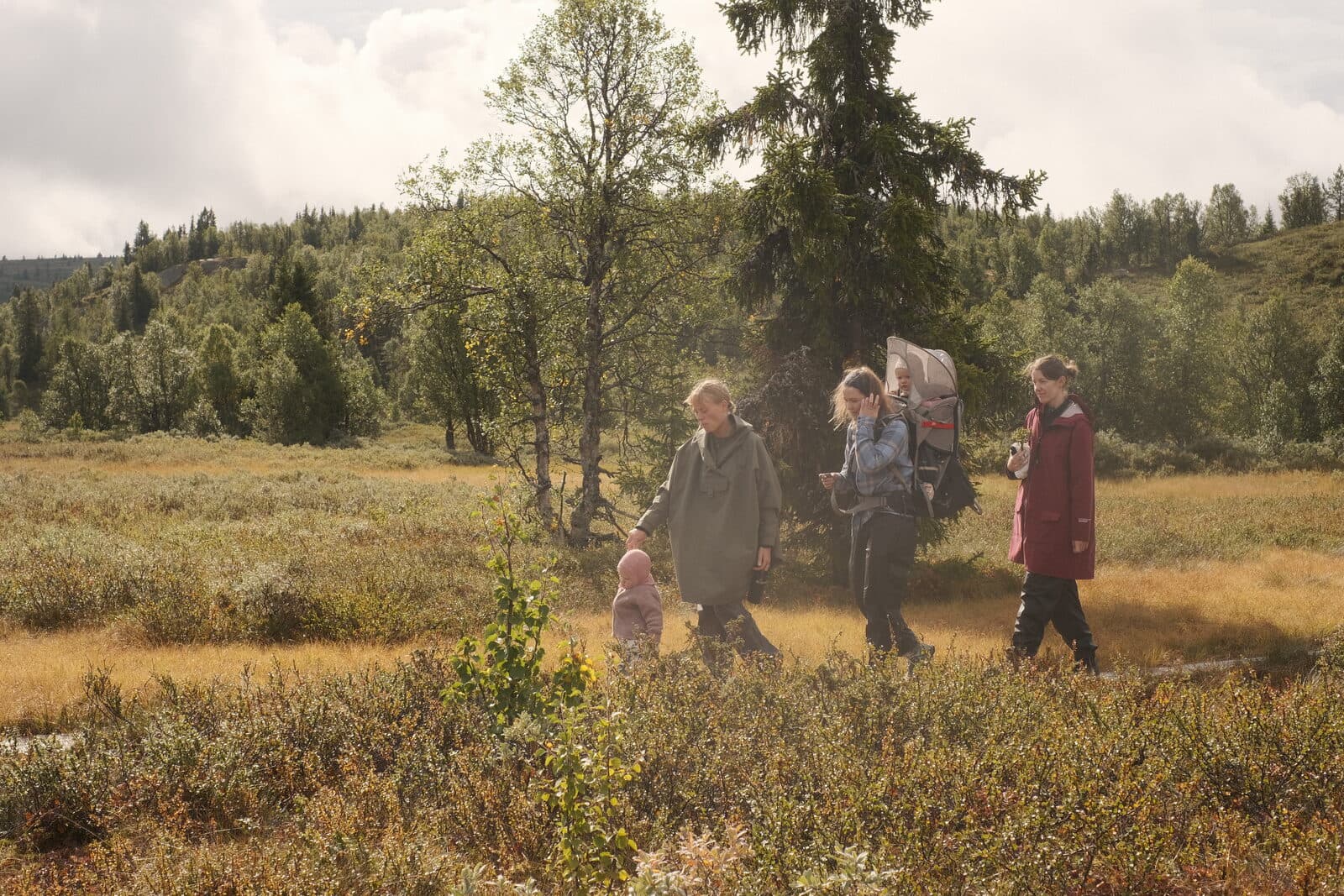 En familie går på tur over myra med et lite barn